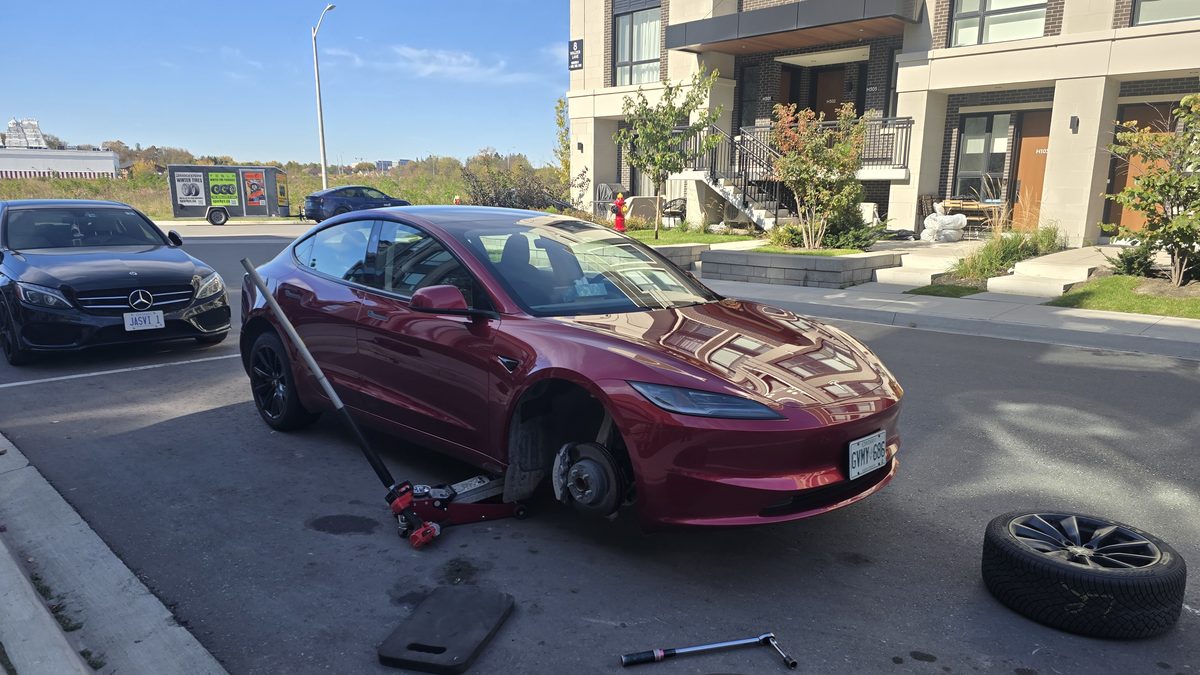 Sparky X Tesla tire service in Pickering — red Tesla with its front wheel removed during a winter tire change