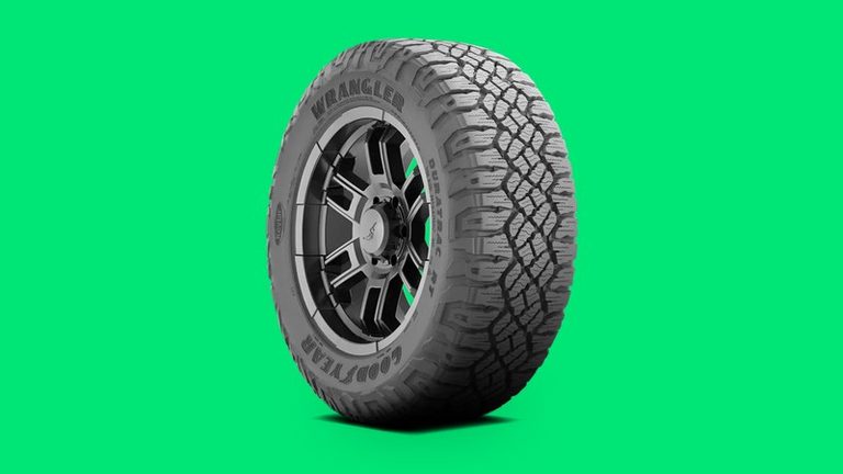 Goodyear Wrangler DuraTrac RT rugged-terrain tire on a vivid emerald background